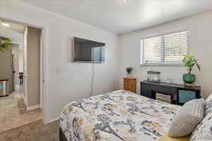 Bedroom featuring light carpet and baseboards