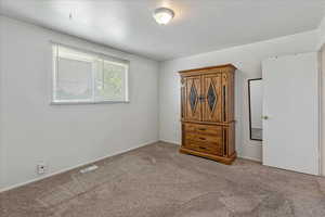 Unfurnished bedroom with carpet floors and baseboards