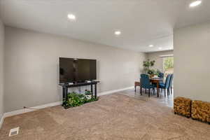 Carpeted living area featuring recessed lighting