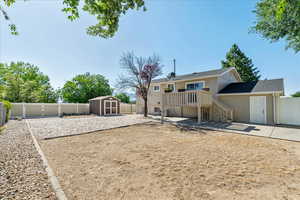 Rear view of house featuring a storage shed, a fenced backyard, and a patio area