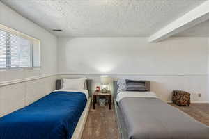 Carpeted bedroom with a textured ceiling