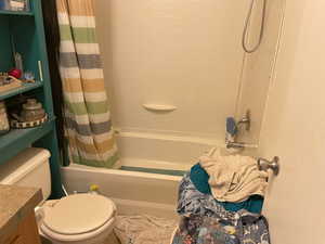 Full bath with shower / bath combo with shower curtain and vanity