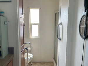 Bathroom featuring a shower stall and toilet