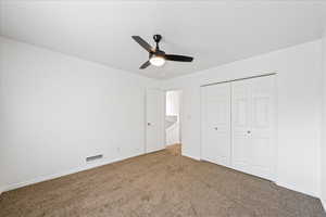 Unfurnished bedroom with carpet floors, a closet, and ceiling fan