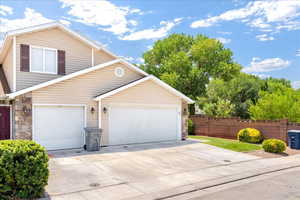 View of front of home with concrete driveway and stone siding