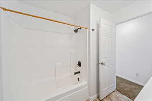 Bathroom with shower / bath combination and baseboards