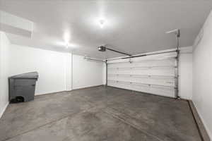 Garage featuring baseboards and a garage door opener