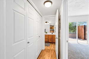 Hallway with light wood-style flooring and a textured ceiling