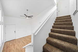 Stairway featuring wood finished floors and ceiling fan