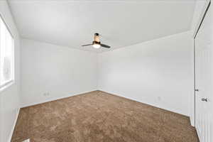 Unfurnished room featuring carpet and a ceiling fan