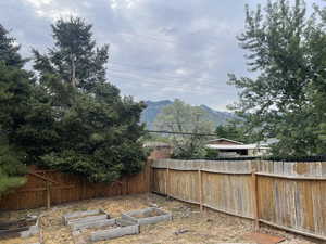Fenced backyard featuring a garden and a mountain view