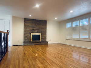 Unfurnished living room with hardwood / wood-style floors, a fireplace, and recessed lighting