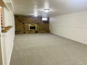Basement featuring carpet and a fireplace