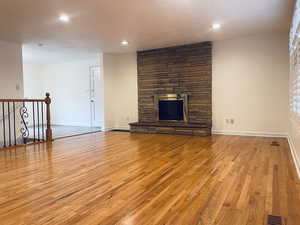 Unfurnished living room with a fireplace, wood finished floors, and recessed lighting