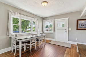 Dining room with a textured ceiling and hardwood / wood-style floors