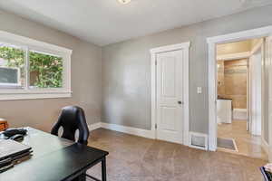 Carpeted office space featuring baseboards and tile patterned floors