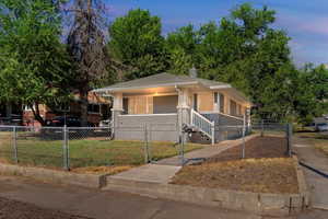 Bungalow with a gate, a chimney, a porch, and a fenced front yard