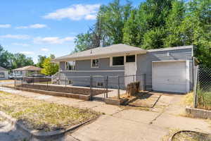 Ranch-style house featuring a gate, a garage, driveway, and a chimney