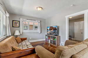 Living room with wood finished floors and a textured ceiling