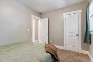 Bedroom with carpet and a textured wall