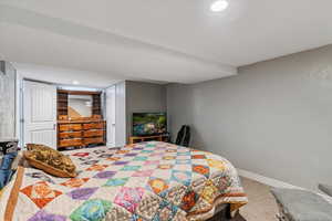 Carpeted bedroom featuring a textured wall and recessed lighting