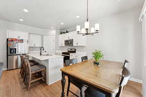 Dining area with a chandelier, recessed lighting, and light wood finished floors
