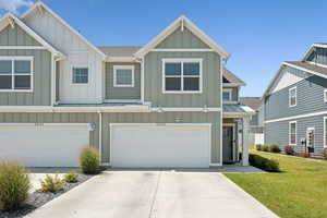 Craftsman-style home featuring board and batten siding, a standing seam roof, driveway, a metal roof, and a garage