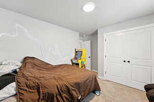 Bedroom featuring light colored carpet and a closet