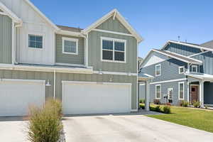 Craftsman inspired home with board and batten siding, driveway, and a garage