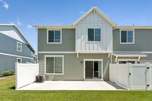 Rear view of property featuring board and batten siding, a patio, and a gate