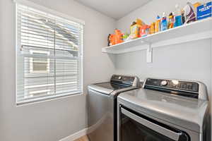 Laundry area featuring separate washer and dryer and baseboards