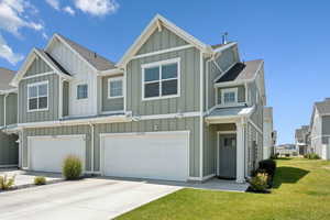Craftsman-style home featuring board and batten siding, a garage, roof with shingles, and concrete driveway