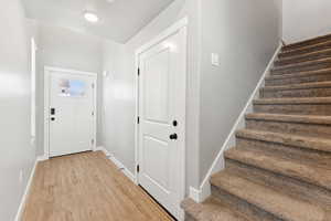 Foyer entrance with stairs and light wood finished floors