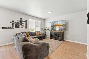 Living room with light wood-style floors and baseboards