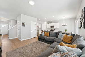 Living area with a chandelier, light wood finished floors, and recessed lighting
