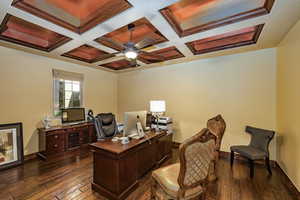 Office space with dark wood-style floors, coffered ceiling, ceiling fan, and beamed ceiling