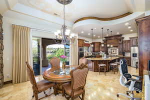 Dining space with a chandelier, recessed lighting, and a raised ceiling