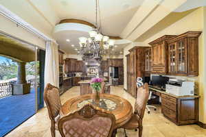 Dining area with a chandelier, lofted ceiling, recessed lighting, and built in study area