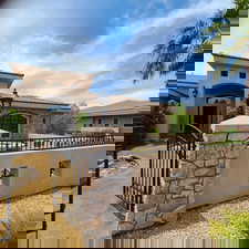 Mediterranean / spanish house with stone siding, stucco siding, a gate, and a tile roof