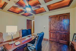 Office area featuring coffered ceiling, a ceiling fan, dark wood-type flooring, and beamed ceiling