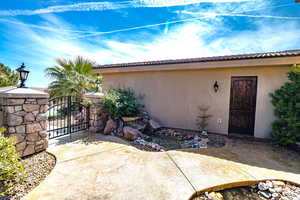 Doorway to property featuring a gate, stucco siding, and a tile roof