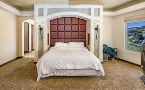 Bedroom featuring carpet and arched walkways