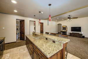 Kitchen with arched walkways, a breakfast bar, recessed lighting, a ceiling fan, and hanging light fixtures