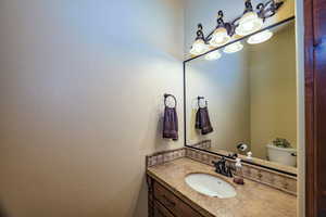 Half bathroom with vanity and toilet