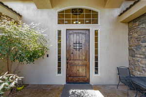 Property entrance featuring stucco siding and stone siding