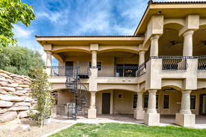 Back of house featuring stucco siding, stairway, ceiling fan, a patio, and a balcony