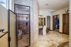 Bathroom featuring a stall shower, vanity, and a spacious closet