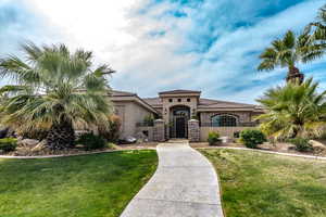 Mediterranean / spanish home with stone siding, stucco siding, a front lawn, and a tiled roof