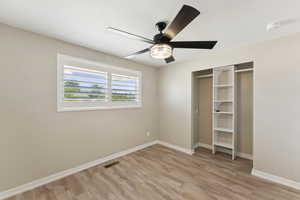 Unfurnished bedroom featuring light wood-style floors, a ceiling fan, and a closet