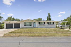 Ranch-style house featuring concrete driveway, brick siding, a garage, and a chimney